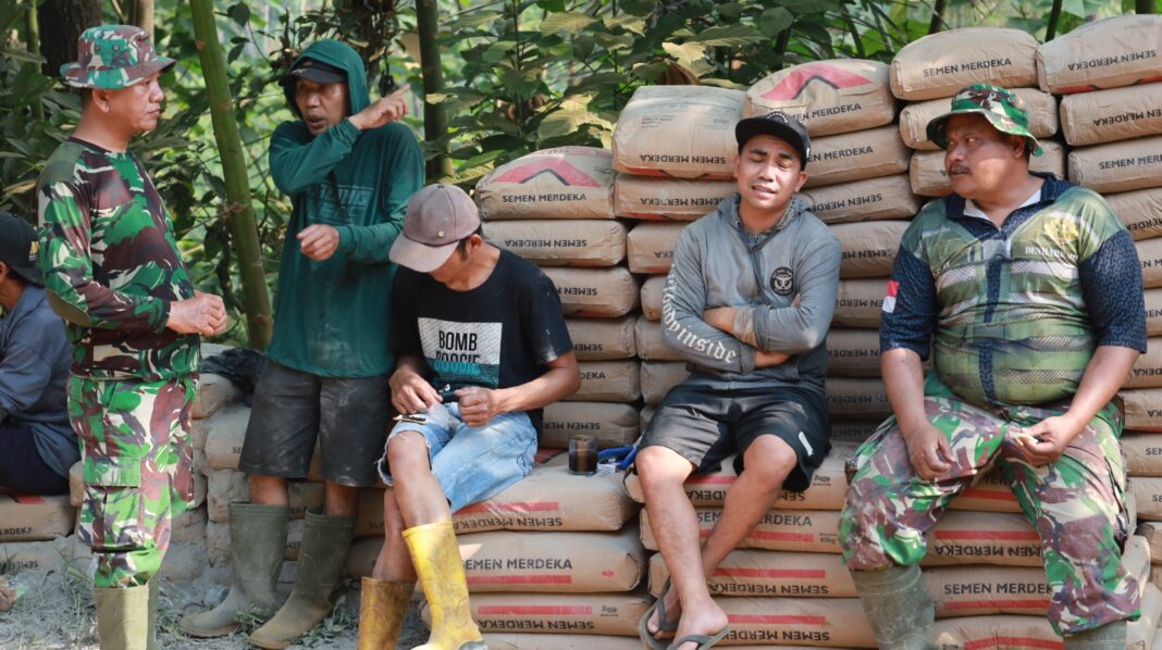 Semen Jadi Tempat Duduk, TNI dan Warga Ngobrol Santai di Tengah TMMD Semen Jadi Tempat Duduk, TNI dan Warga Ngobrol Santai di Tengah TMMD